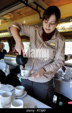 Une serveuse servant du café frais aux passagers à bord du restaurant de première classe du train Ghan en Australie Banque D'Images