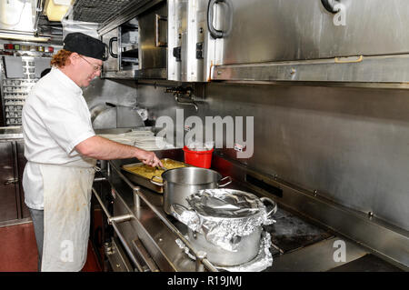 Un chef prépare un déjeuner dans la cuisine à bord du train Ghan en Australie. Le Ghan train assure une liaison ferroviaire directe entre Adélaïde au sud Banque D'Images