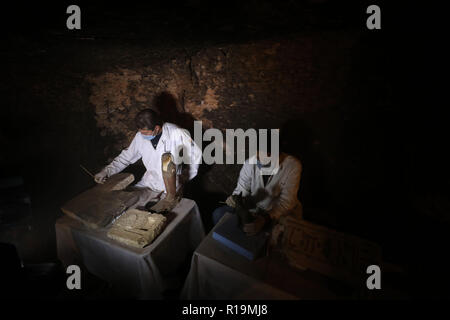 Giza, Egypte. 10 Nov, 2018. Les archéologues égyptiens travaillent à l'intérieur du tombeau de Khufu-Imhat l'un des sept tombes appartenant à la nouvelle et anciens royaumes de l'Égypte. Une mission archéologique égyptienne a découvert sept nouveaux tombeaux de Saqqarah nécropole avec des dizaines de momies de chat, des centaines de statues en bois de chats et une médaille de bronze, qui consacre à "Bastet", la déesse adoré dès la deuxième dynastie (2890 avant notre ère). Credit : STR/afp/Alamy Live News Banque D'Images