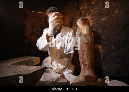 Giza, Egypte. 10 Nov, 2018. Un archéologue égyptien travaille à l'intérieur de la tombe d'Khufu-Imhat, une des sept nouvelles tombes appartenant à la nouvelle et anciens royaumes de l'Égypte. Selon le Ministère égyptien des antiquités, une mission archéologique égyptienne a découvert sept nouveaux tombeaux de Saqqarah nécropole avec des dizaines de momies de chat, des centaines de statues en bois de chats et une médaille de bronze, qui consacre à "Bastet", la déesse adorée dès la deuxième dynastie (2890 avant notre ère). Credit : Stringer/dpa/Alamy Live News Banque D'Images