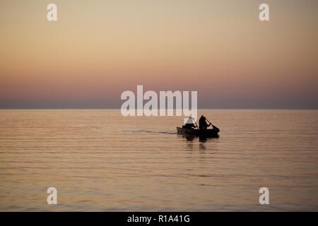 Les gens sur le lac en canoë lors d'un coucher de soleil, Ontario Canada Banque D'Images