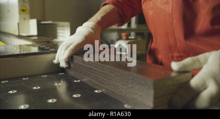 Les travailleurs de porter des gants méconnaissable plancher bois le met en tas à scierie, slow motion close up Banque D'Images