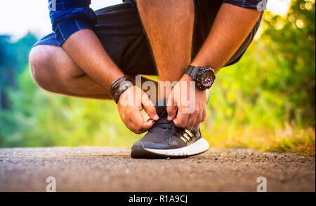 Jeune homme attachant lacets, coureur de fond Sports Banque D'Images