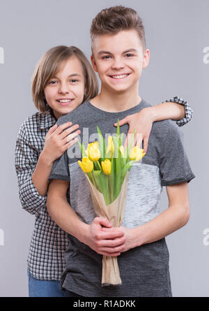 Jeune garçon et fille avec des fleurs Banque D'Images