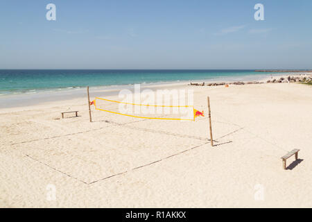 Volley-ball de plage vide prêt à jouer le jeu. Beach-volley dans une belle journée d'été avec ocean et bleu ciel nuageux. Filet de volley-ball sur la plage tropicale. Banque D'Images