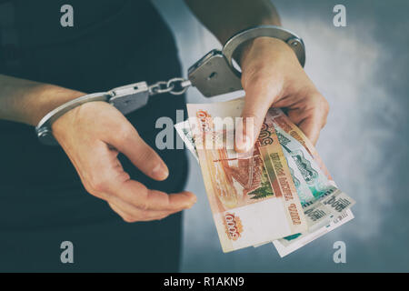 Les mains dans des menottes avec de l'argent russe. Concept d'arrestation pour corruption Banque D'Images
