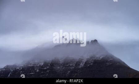 Les sommets de montagnes qui apparaissent à travers les nuages dans le sud de l'Islande Banque D'Images