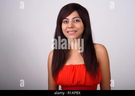 Close up of young happy Persian woman smiling while wearing red Banque D'Images