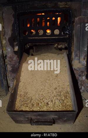 Close up of Brown les briquettes de charbon en feu avec flammes jaunes rouge à l'intérieur d'un four spécial, solide rouge et orange texture floue sur un fond noir. Banque D'Images