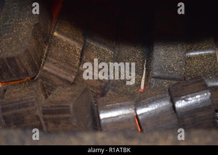 Close up of Brown les briquettes de charbon en feu avec flammes jaunes rouge à l'intérieur d'un four spécial, solide rouge et orange texture floue sur un fond noir. Banque D'Images