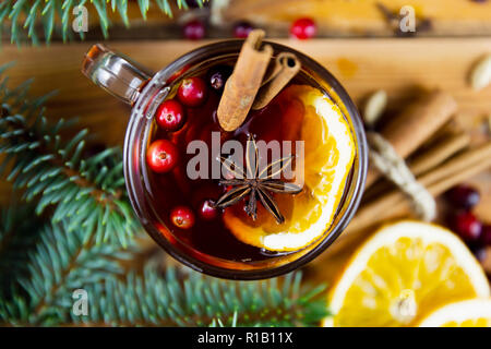 Vin chaud de Noël à la cannelle, les épices et les rondelles d'orange sur un fond de bois. Boisson chaude d'hiver Banque D'Images