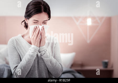 Close up of young woman blowing her nose Banque D'Images