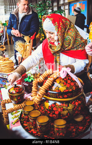 Gomel, Bélarus - 18 Février 2018 : une femme lors d'une foire dans la châle biélorusse vend des crêpes à Mardi Gras Banque D'Images