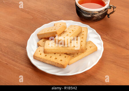 Une photo de sablés écossais, le beurre des cookies sur un fond rustique avec une tasse de thé vintage et copy space Banque D'Images