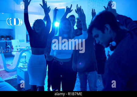 Voir de jeunes gens modernes la danse de lumière bleue avec le DJ joue de la musique sur la célébration du Nouvel An Banque D'Images