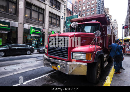 La ville de New York, USA - 25 juillet 2018 : Truck Driver se reposant dans une remorque rouge de la marque Mack dans Manhattan à New York City, USA Banque D'Images