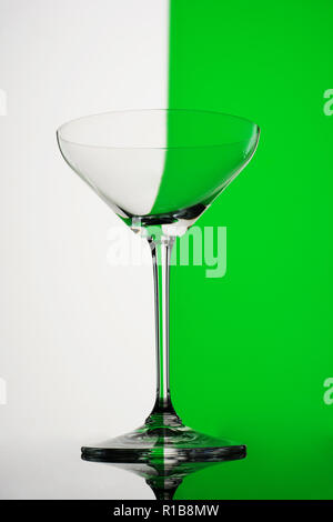 Verre à martini vide sur fond blanc et vert Banque D'Images