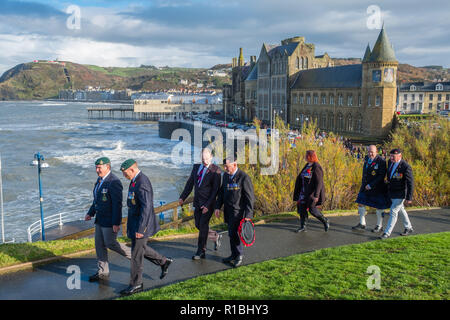 Pays de Galles Aberystwyth UK, 11/11/2018. Les gens se réunir pour déposer des couronnes et d'hommage aux soldats tombés dans toutes les guerres et les conflits, le Dimanche du souvenir, et le 100e anniversaire de l'Armistice qui mit fin à la Première Guerre mondiale, dans des conditions très venteuses mais lumineux à l'emblématique monument commémoratif de guerre dans le château pointe à Aberystwyth sur les côtes de la Baie de Cardigan, West Wales crédit photo Keith Morris / Alamy Live News Banque D'Images