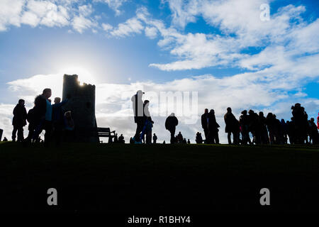 Pays de Galles Aberystwyth UK, 11/11/2018. Les gens se réunir pour déposer des couronnes et d'hommage aux soldats tombés dans toutes les guerres et les conflits, le Dimanche du souvenir, et le 100e anniversaire de l'Armistice qui mit fin à la Première Guerre mondiale, dans des conditions très venteuses mais lumineux à l'emblématique monument commémoratif de guerre dans le château pointe à Aberystwyth sur les côtes de la Baie de Cardigan, West Wales crédit photo Keith Morris / Alamy Live News Banque D'Images