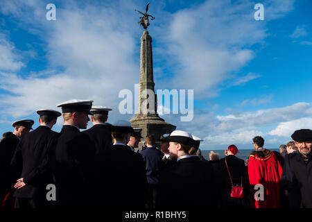 Pays de Galles Aberystwyth UK, 11/11/2018. Les gens se réunir pour déposer des couronnes et d'hommage aux soldats tombés dans toutes les guerres et les conflits, le Dimanche du souvenir, et le 100e anniversaire de l'Armistice qui mit fin à la Première Guerre mondiale, dans des conditions très venteuses mais lumineux à l'emblématique monument commémoratif de guerre dans le château pointe à Aberystwyth sur les côtes de la Baie de Cardigan, West Wales crédit photo Keith Morris / Alamy Live News Banque D'Images