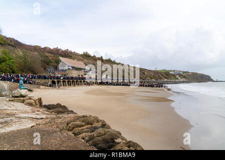 Folkestone, Kent, Angleterre. 11 novembre 2018. Les gens de la mer, sous un ciel gris, de regarder un portrait de sable de Wilfred Owen lentement été emportées par la marée montante. 100e anniversaire de la fin de la première guerre mondiale, le souvenir de l'événement Dimanche, 'Pages de la mer'. Banque D'Images