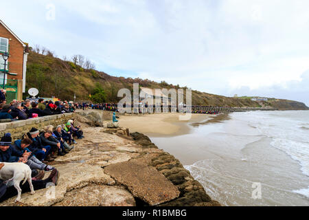 Folkestone, Kent, Angleterre. 11 novembre 2018. Les gens de la mer, sous un ciel gris, de regarder un portrait de sable de Wilfred Owen lentement été emportées par la marée montante. 100e anniversaire de la fin de la première guerre mondiale, le souvenir de l'événement Dimanche, 'Pages de la mer'. Banque D'Images