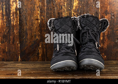 Women's Winter Boots faite de textiles. Chaussures pour voyager et de longues promenades. bottes de saison sur un fond de bois Banque D'Images