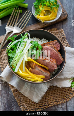 Canard Hoisin avec mangue, oignon de printemps, riz et salade de laitue roquette - Vue de dessus Banque D'Images