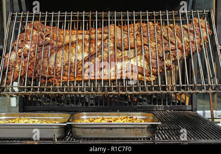 Cochon entier rôti sur un grand grill. Genre d'Cheverme, animal entier rôti sur un gril. Un barbecue géant pour un ensemble de porcs. La cuisson en plein air cochon. Banque D'Images