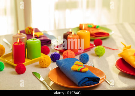 Les plaques multicolores et des serviettes en lin avec décor en tricot. Réglage de la table pour l'automne ou hiver saison froide - Thanksgiving, Halloween, Noël et Banque D'Images