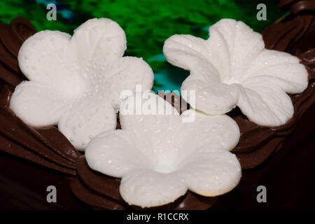Fondant blanc trois fleurs sur le gâteau au chocolat Banque D'Images