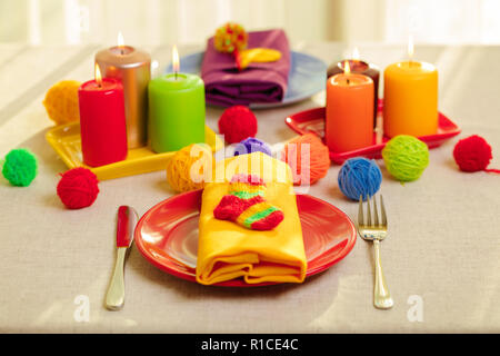 Les plaques multicolores et des serviettes en lin avec décor en tricot. Réglage de la table pour l'automne ou hiver saison froide - Thanksgiving, Halloween, Noël et Banque D'Images