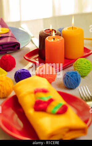 Les plaques multicolores et des serviettes en lin avec décor en tricot. Réglage de la table pour l'automne ou hiver saison froide - Thanksgiving, Halloween, Noël et Banque D'Images
