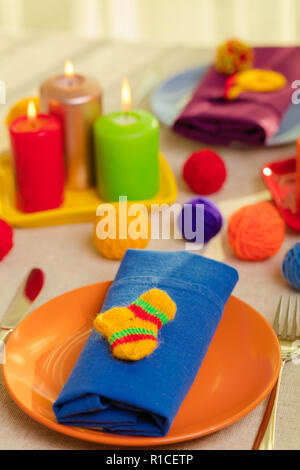 Les plaques multicolores et des serviettes en lin avec décor en tricot. Réglage de la table pour l'automne ou hiver saison froide - Thanksgiving, Halloween, Noël et Banque D'Images