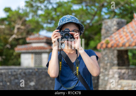 Touriste japonais de prendre une photo avec un Nikon F3 appareil photo ; Mabuni Hill Observation Deck, Itoman, Okinawa, Japon Banque D'Images