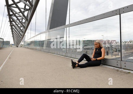 Runner assis sur Bridge après entraînement et l'utilisation de Smart Phone Banque D'Images