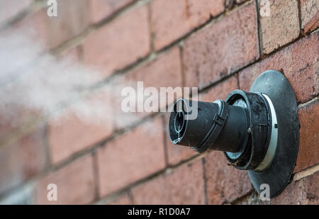 Les gaz d'échappement et de la vapeur d'eau provenant d'une chaudière à gaz combi via le tuyau de cheminée extérieure. Banque D'Images