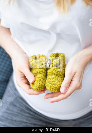 Libre femme hands holding baby booties Banque D'Images