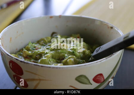 Avocado Guacamole mexicain sur molcajete procédure traditionnelle. Banque D'Images