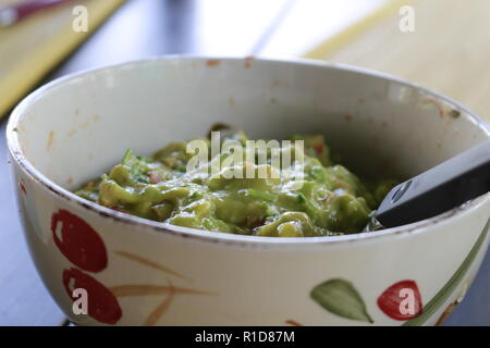 Avocado Guacamole mexicain sur molcajete procédure traditionnelle. Banque D'Images