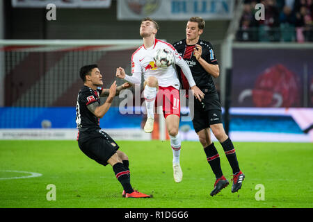 Leipzig, Allemagne. 11Th Nov, 2018. Leipzig's Timo Werner (C) rivalise avec Leverkusen's Sven Bender (R) et Charles Aranguiz lors d'un match de Bundesliga allemande entre Leipzig et Bayer 04 Leverkusen à Leipzig, Allemagne, le 11 novembre 2018. Leipzig a gagné 3-0. Crédit : Kevin Voigt/Xinhua/Alamy Live News Banque D'Images