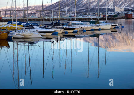 Bateaux qui réfléchit sur l'eau dans le port de Tromso en hiver Banque D'Images