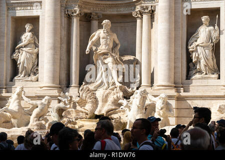 Statues de la fontaine de Trevi regarder vers le bas sur des hordes de touristes en visite. La fontaine de Trevi est l'un des plus populaires attractions touristiques de Rome, il Banque D'Images