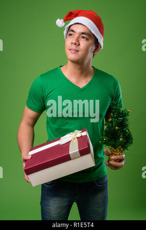Beau jeune homme de son pays prêt pour Noël contre green ba Banque D'Images