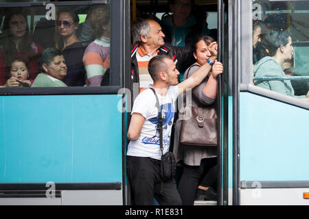 Un petit bus local plein de l'éclatement ramasse les passagers au milieu de Gjirokaster, dans le sud de l'Albanie. Banque D'Images