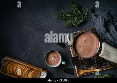 Vue de dessus du chocolat chaud dans une tasse et pot sur fond sombre. Copy space Banque D'Images