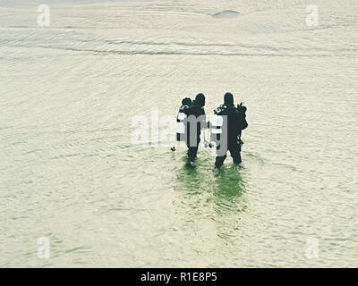 Prerow Allemagne - le 25 janvier 2018 : deux plongeurs de mer à pied de la plage de la mer. Fin de plongée. Banque D'Images