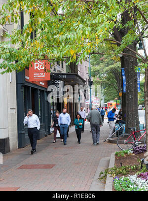 CHARLOTTE, NC, USA-10/30/18 : Smiling people à pied pour le déjeuner ; un homme parle sur téléphone cellulaire. Banque D'Images