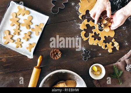 Noël Nourriture concept. Gingerbread man man cooking cookies dans Noël en vue de dessus de table en bois. Dessert de Noël Banque D'Images