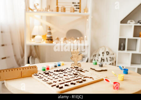 Les numéros en bois et d'une règle sont sur la table parmi les peintures colorées dans la chambre. Banque D'Images